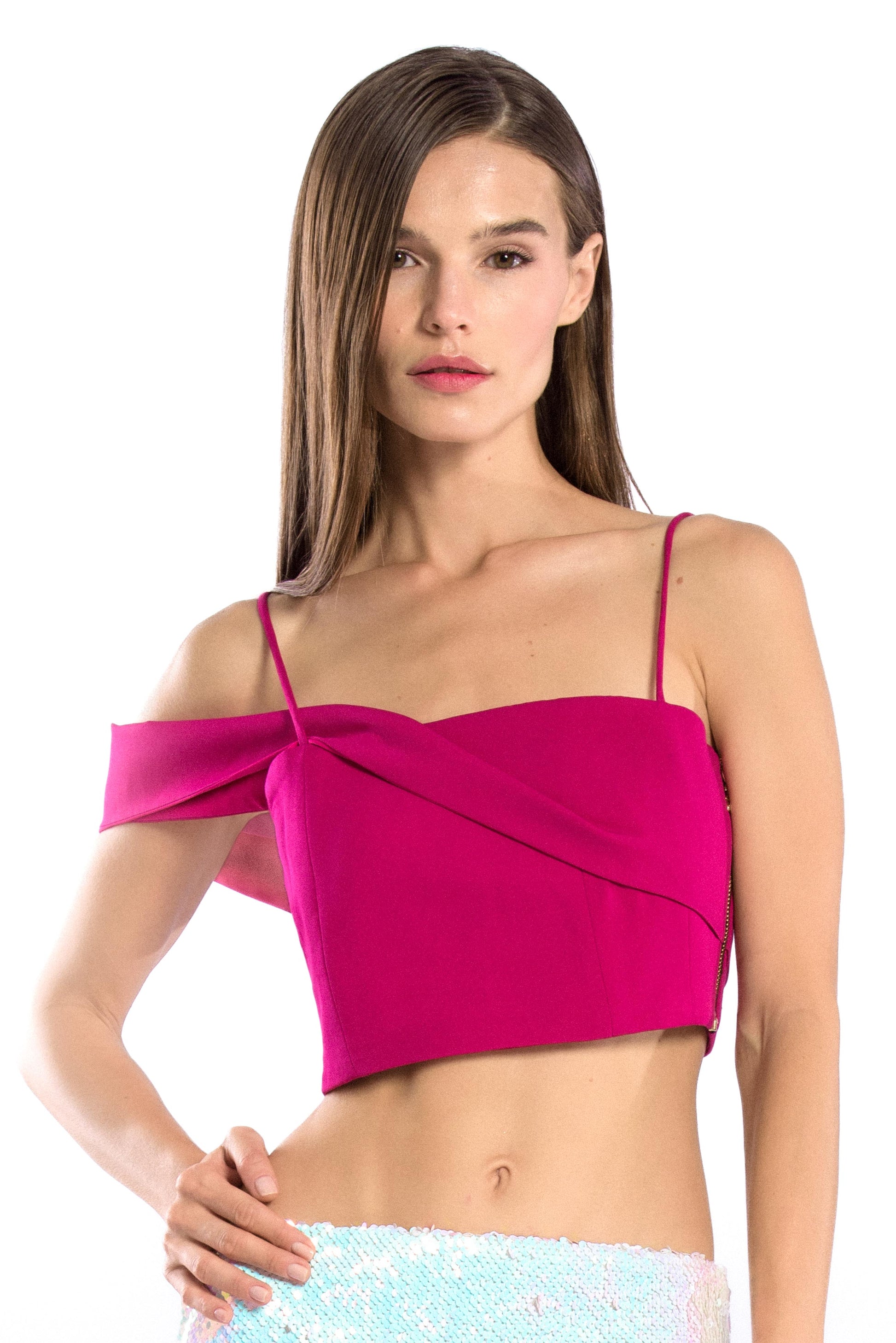 Model wearing asymmetric off shoulder crop top in hot pink